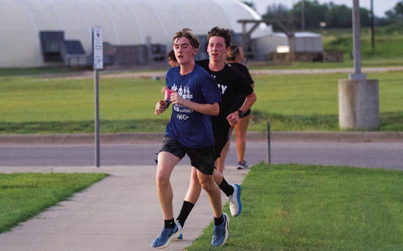 Parker Boykin, front, and Gabriel Allison round the corner during the Monday morning run. HUNTER KING | DISPATCH RECORD