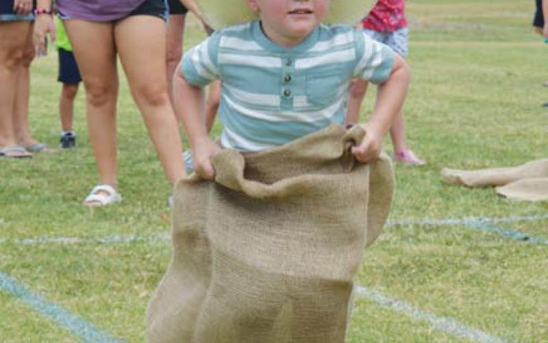 Baker Thompson keeps a hold of his cowboy hat while competing in sack races during Spring Ho Kids’ Day activities. hunter king | LAMPASAS DISPATCH RECORD