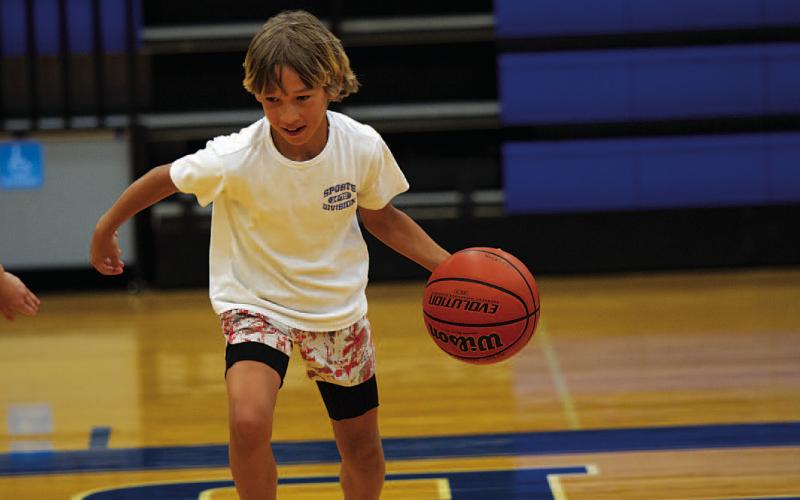 Kaylor Chapa dribbles as the kids compete in a game at the end of the first day of camp. HUNTER KING | DISPATCH RECORD