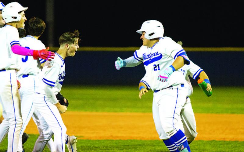 Benny Rodriguez (21) celebrates with his teammates after knocking in the winning run. HUNTER KING | DISPATCH RECORD