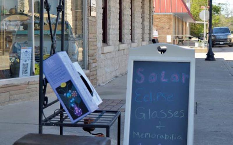 A sign outside The Trading Post on the downtown square advertises the sale of solar eclipse glasses. Many businesses and local residents are gearing up for the solar eclipse on April 8. Erick Mitchell | dispatch record