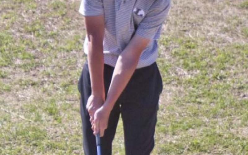 Aiden Wiley hits a chip shot during round one of the district golf tournament, played Monday at Glen Rose. JEFF LOWE | DISPATCH RECORD