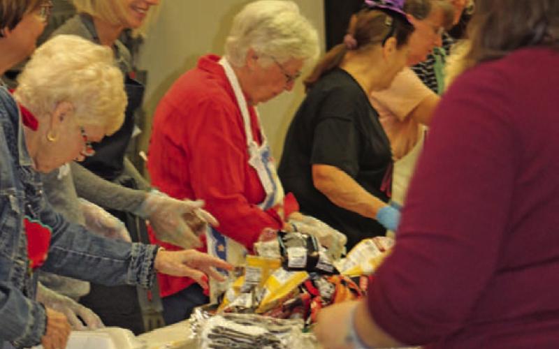 Lampasas Public Library staff, board members and volunteers stand shoulder to shoulder fixing lunch plates on Monday for the library’s biggest fundraiser of the year. All proceeds from the BBQ for Books event go toward the purchase of large-print books, for community programs and needed equipment. JOYCESARAH MCCABE | DISPATCH RECORD