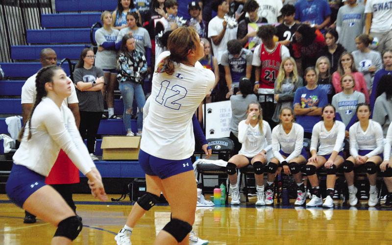 Maggie Fletcher, right, plays a pass as Emily Cain backs her up during the Lady Badgers’ match against Shoemaker.