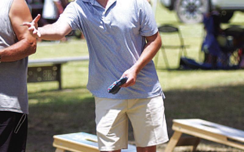 HUNTER KING | DISPATCH RECORD Nate Borchardt tosses a beanbag during the cornhole tournament.
