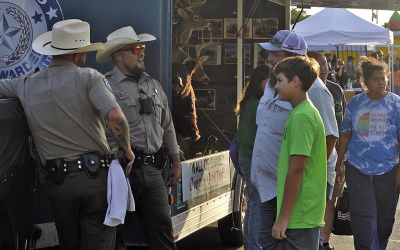 ERICK MITHCELL | DISPATCH RECORD Lampasas residents stop by for a chat at the Texas Game Warden booth at Tuesday’s National Night Out celebration.