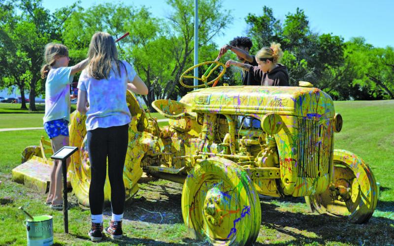 From left to right, Amie Harper, Piper Lindner, Umari Carter and Camryn Brown splatter-paint a tractor during LAFTA’s Arts in the Park event on Saturday. ERICK MITCHELL | DISPATCH RECORD
