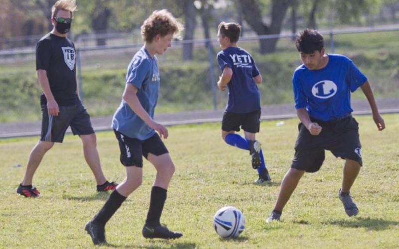 Coach Edward Gold, far left, watches Solomon Storm and Alex Montiel, far right, go through a drill on Tuesday while Tate Langford, back-center, jogs back to a line. JEFF LOWE | DISPATCH RECORD