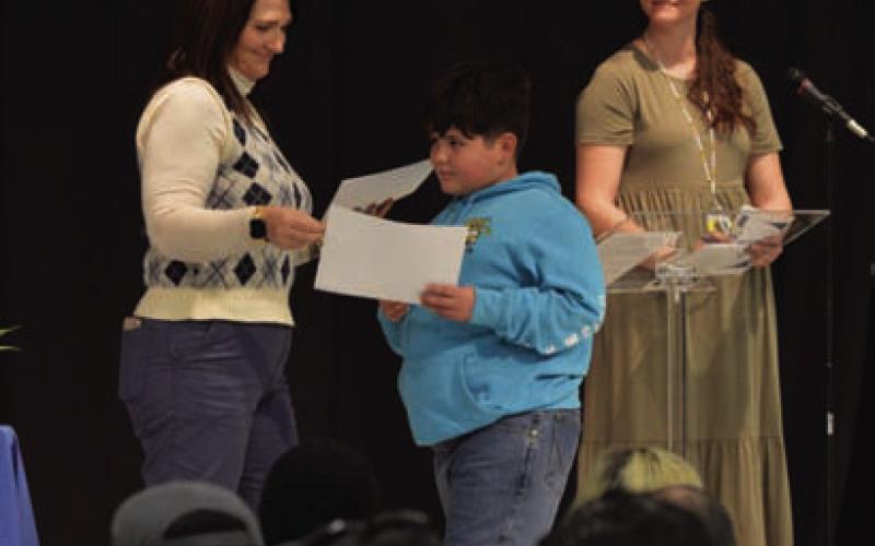 At center, Warren Jennings receives his master’s degree certificate from Instrucional Specialist Kasey Borland, as RTI Coordinator Sarah Schoonover looks on. ERICK MITCHELL | DISPATCH RECORD