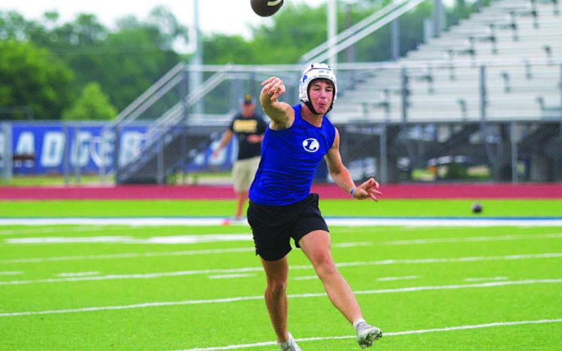 HUNTER KING | DISPATCH RECORD JT Posten rolls right and makes a throw during 7-on-7 on Tuesday night.