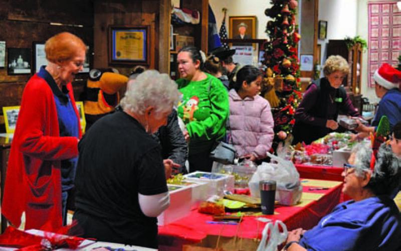 Lampasas County Museum visitors eye the perfect sweet treat during the museum’s annual bake sale during Carol of Lights events on Saturday, ERICK MITCHELL | DISPATCH RECORD