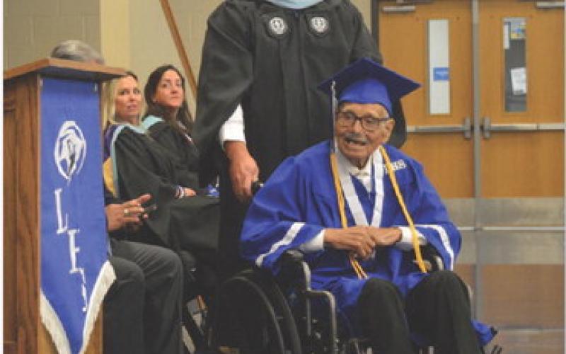 Lampasas High School Assistant Principal Ryan Race assists Guadalupe “Wally” Dimas as he waits to receive his hgh school diploma last week – something Dimas has yearned for most of his adult life. ERICK MITCHELL | DISPATCH RECORD