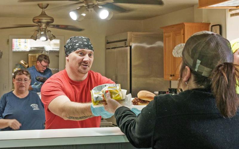 Adam barrios | DISPATCH RECORD Kempner Volunteer Fire Department member Steve Martin serves a lunch plate during the department’s annual BBQ Fundraiser and Auction on Saturday.