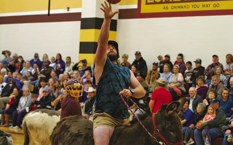 HUNTER KING | LAMPASAS DISPATCH RECORD Sam Pauly tosses the ball toward the hoop during Saturday night’s Donkey Basketball game.