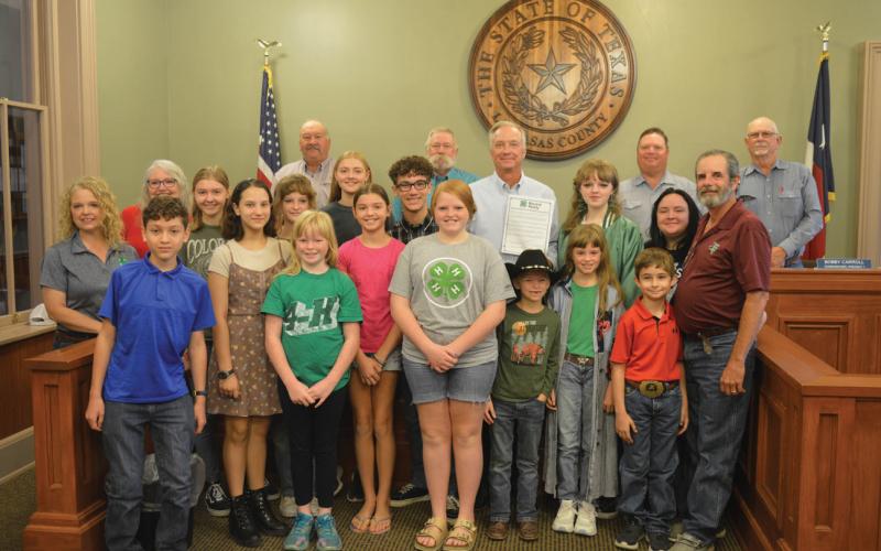 Lampasas County commissioners and County Judge Randy Hoyer (holding a resolution) pose for a photo with area 4-H students and leaders after approval of the proclamation highlighting National 4-H Week that runs Oct. 6-12. erick mitchell | dispatch record