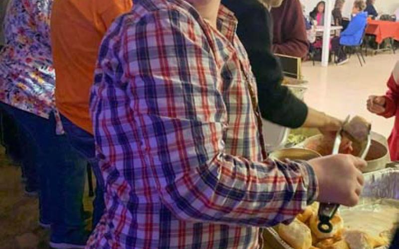 Wings of Eagles Outreach participant Johnathan Pickard serves a meal to veterans during a recent community service event at Community Kitchen. COURTESY PHOTO