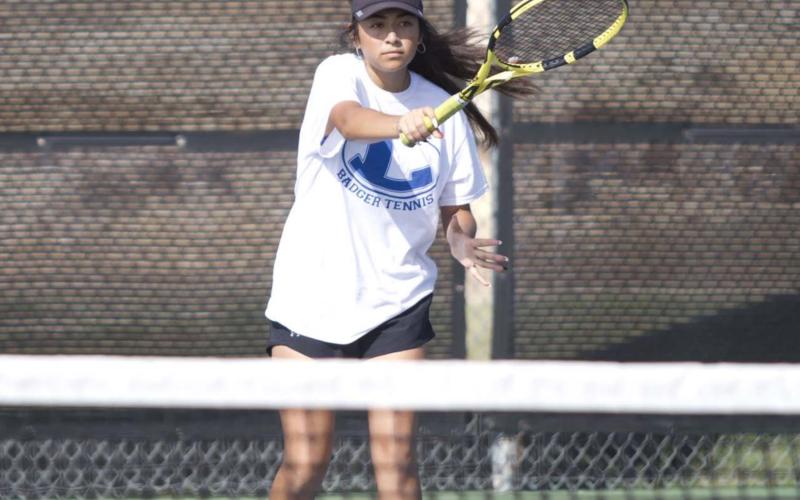 Junior Amore Zapata follows through on a forehand return during a doubles match against Leander last week. She and Alyssa Sharkey won their most recent match in straight sets. HUNTER KING | DISPATCH RECORD