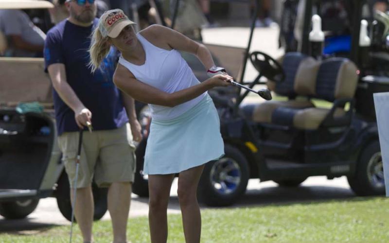 Carmen Gonzalez follows through on a shot during the chipping contest on Saturday. HUNTER KING | DISPATCH RECORD