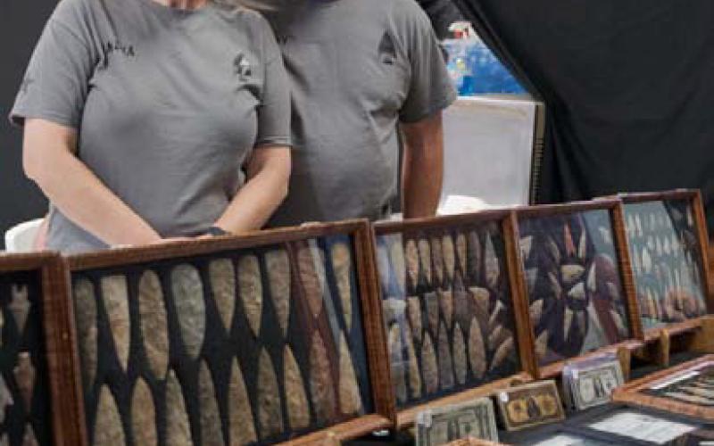 India Houser and Bobby Buscha pose in front of a collection of arrow and spear heads. GABRIELA SANGACHE |DISPATCH RECORD