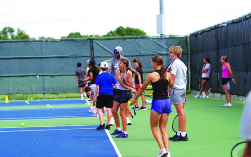 Older students practice their serving at tennis camp. HUNTER KING | DISPATCH RECORD