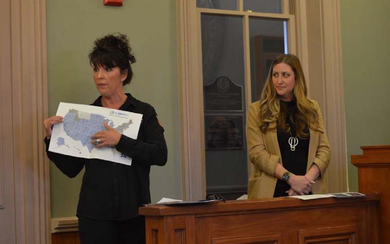 At left, Shae Brewer of AirMedCare Network displays a map to show the Commissioners Court where the company’s medical evacuation services are available. Paige Carter, a CareFlight representative, also was at Monday’s meeting to explain membership benefits the company can offer. ERCK MITCHELL | DISPATCH RECORD