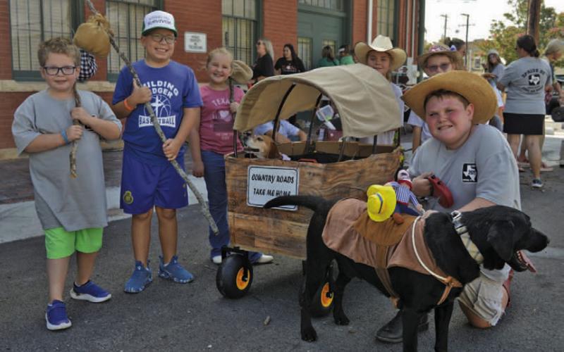Left to right, Olson Isom, Chance Walsh, Harper Harrison, Katy Milam, Paxton Roberts and Bradley Milam pose for a photo with dogs “Pluto,” who takes a breather in the wagon, and “Buster.” ERICK MITCHELL | DISPATCH RECORD