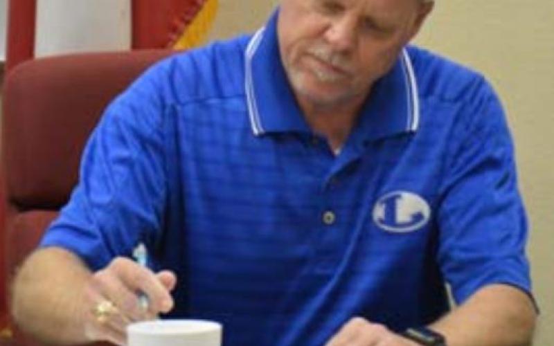 Randy Morris, vice president of the school board, signs oath-of-office paperwork during Monday’s meeting. MONIQUE BRAND | DISPATCH RECORD