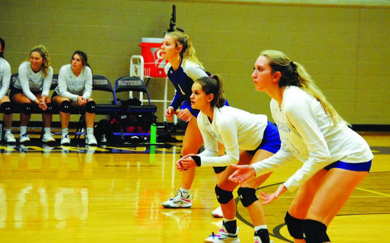 Quarles, left, Syx and Breana Pelbath await a serve from Salado during Tuesday’s playoff game. HUNTER KING | DISPATCH RECORD