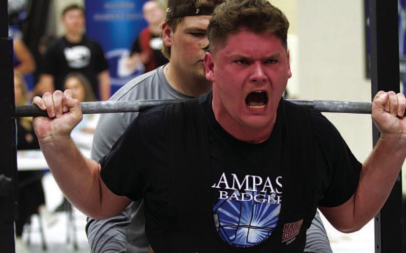 Deegan Norwood strains to lift during the squat portion of last week’s powerlifting meet. HUNTER KING | DISPATCH RECORD