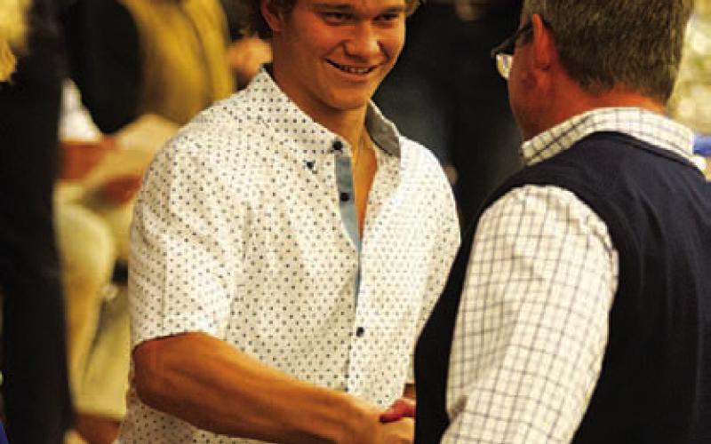 Haegan Oncken shakes Rogers’ hand after being awarded the Receiver of the Year honor for his 2023 season. HUNTER KING | DISPATCH RECORD