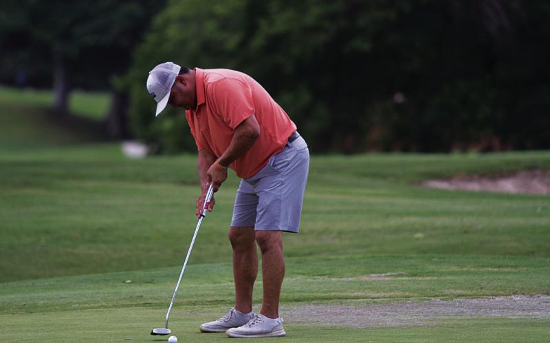 Harvey Stinnett hits a putt during the KM two-man scramble at Hancock Park Golf Course last Friday. HUNTER KING | DISPATCH RECORD