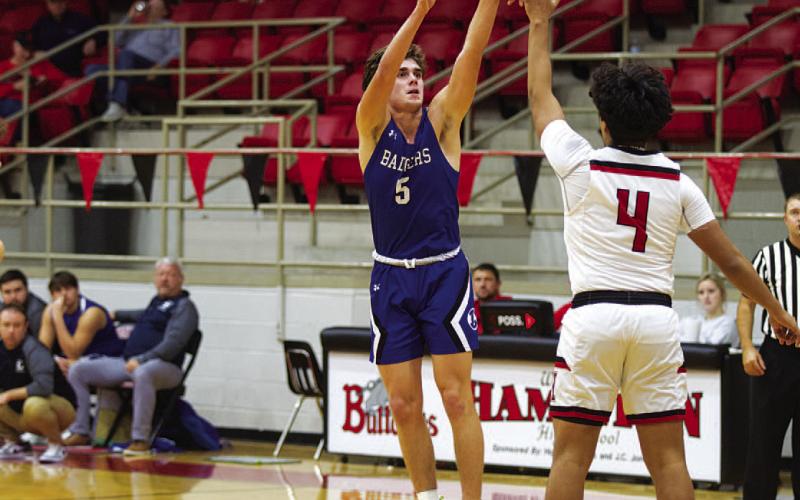 Trent Seneca shoots a three-point shot over a defender. HUNTER KING | DISPATCH RECORD