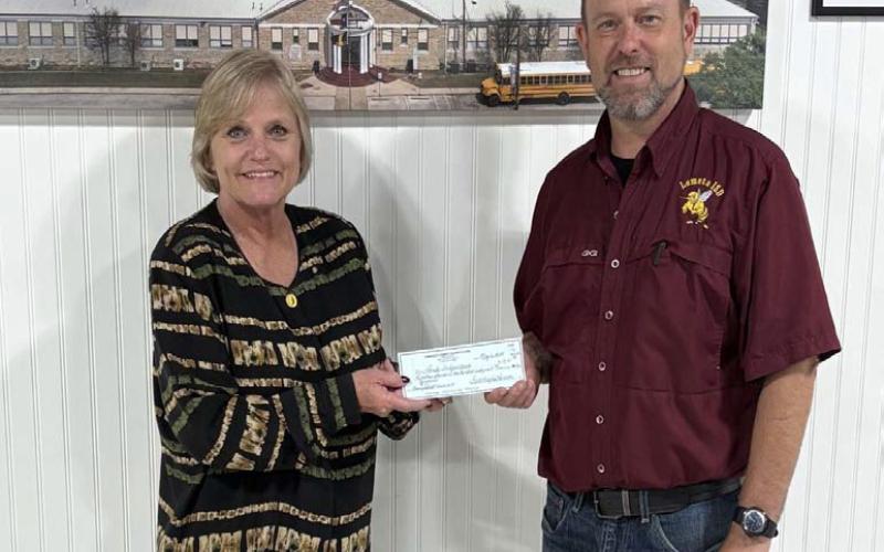 District Clerk Edith Wagner Harrison presents Lometa ISD Superintendent Rob Moore with a check for $19,161. The funds will assist the school district with furnishing supplies for the new automotive program. COURTESY PHOTO