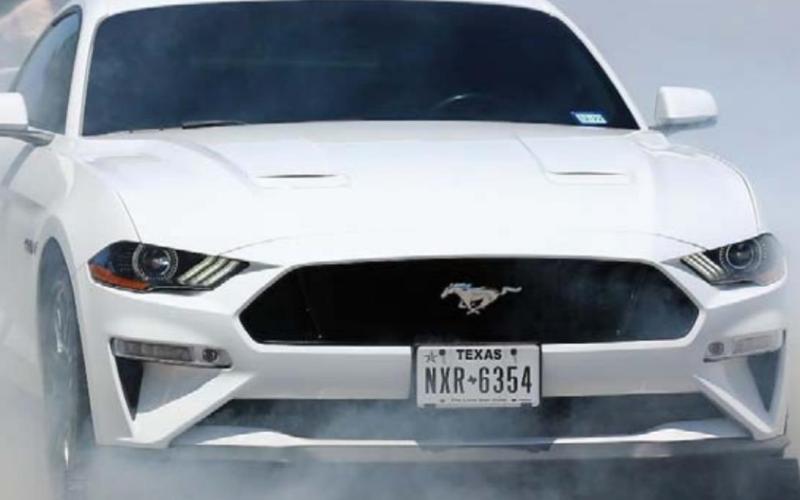 A white Ford Mustang burns out during Saturday’s event. CHRIS MILES | DISPATCH RECORD