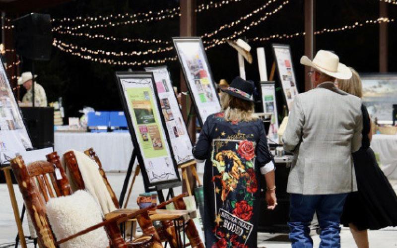 Boots and Blazers Ball attendees scope out items available for auction in last year’s event. FILE PHOTO