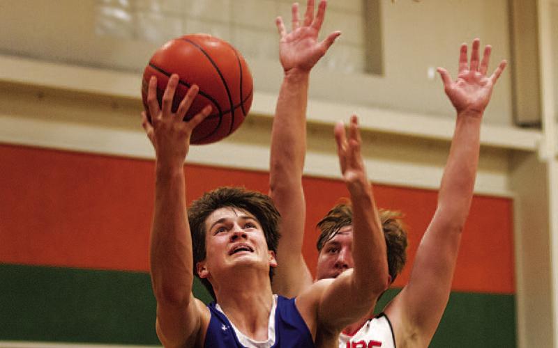 HUNTER KING | DISPATCH RECORD Calum Mitchell jumps toward the basket during the district finale.