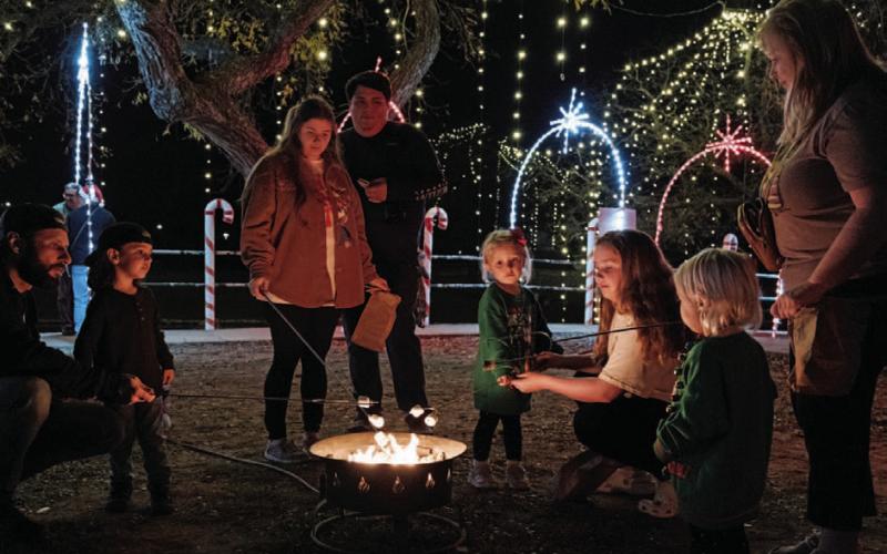 At left, families spend time making s’mores while enjoying the Christmas on the Creek holiday lights along Sulphur Creek. Guests had the opportunity to partake of hot chocolate, cotton candy and s’mores as they walked the pathway of lights and visited Santa’s Christmas village.