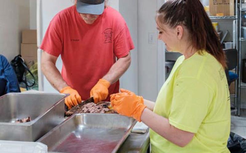 Kempner Volunteer Fire Department Capt. Todd Burkett and volunteer Casey Chapman prepare food for the annual barbecue fundraiser. gabriela sangache | dispatch record