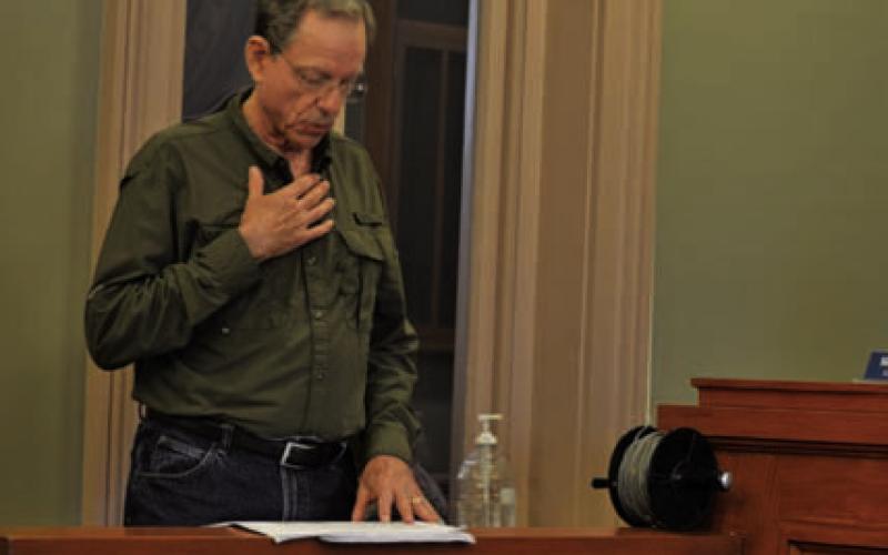 Mike Watson checks his notes while making a presentation to the Commissioners Court on managementneedsoftheSaratogaUnderground Water Conservation District. ERICK MITCHELL | DISPATCH RECORD