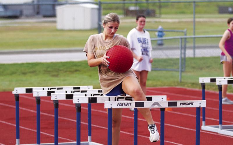 Meredith McBeth moves through the hurdles for a hip flexibility exercise. HUNTER KING | DISPATCH RECORD