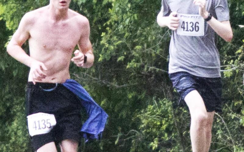 Ben Stone, left, stays in a close race with Nicolas Murphy of Cedar Park. Stone -- the Lampasas High School cross country Battlin’ Badger this year -- won the Boys’ 12-15 division of the 5K as part of Spring Ho weekend. JEFF LOWE | DISPATCH RECORD