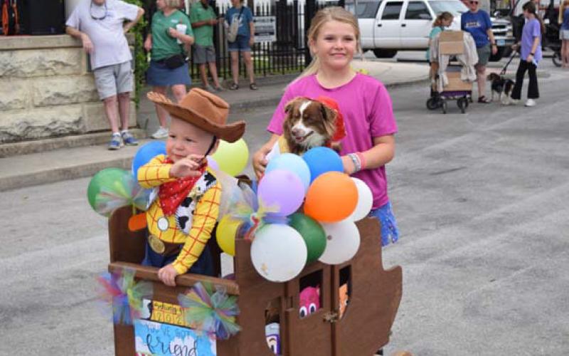 Tye Langford, right, leads Eli Joseph Straley, left, and puppy pal Lori Darlin’, center, in a “Toy Story”-themed parade display on Friday morning. The three won Pet Parade Grand Champion honors for Tate Langford, not pictured. ALEXANDRIA RANDOLPH | DISPATCH RECORD