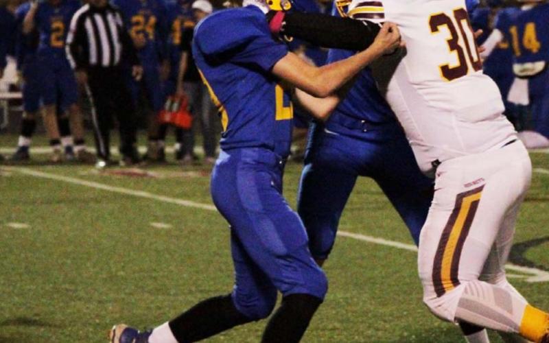 Adrian Smailus-Cruz tries to fight through two Medina blockers during the Hornets’ win last Thursday. JESSICA MALDONADO | DISPATCH RECORD
