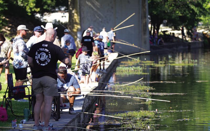 Poles lined the creek in W.M. Brook Park for the fishing derby. HUNTER KING | DISPATCH RECORD