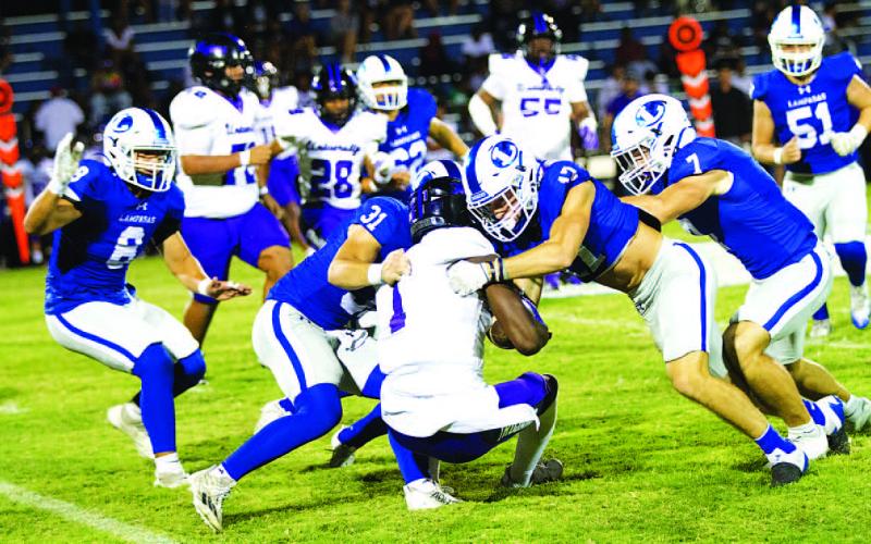Tate Langford (31), Sean Smith (17) and Aaron Everts (7) are in on the tackle for the Badgers. HUNTER KING | DISPATCH RECORD