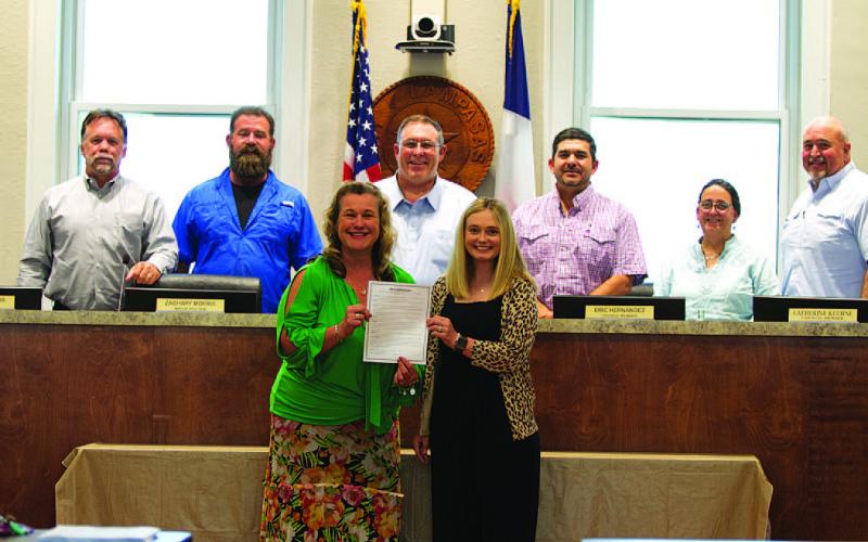 Becky Sims, left, and Kayleigh Stanley pose with the city council after being recognized for Professional Municipal Clerks Week at Monday’s meeting. HUNTER KING | DISPATCH RECORD