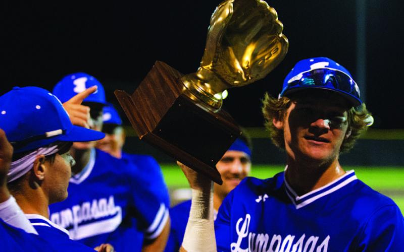 Timber Gholson shows off the gold glove from winning the area round of the playoffs. HUNTER KING | DISPATCH RECORD
