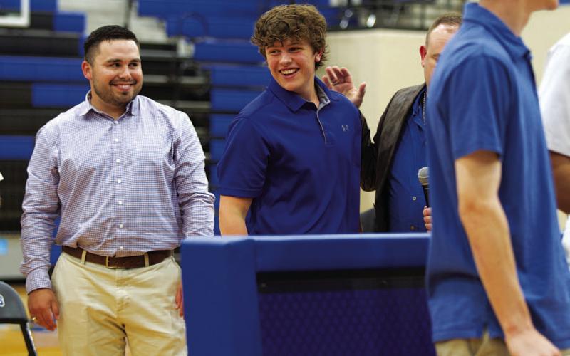 Aidan Nuckles smiles as he takes his certificate from his coach and father, Aaron Nuckles. HUNTER KING | DISPATCH RECORD