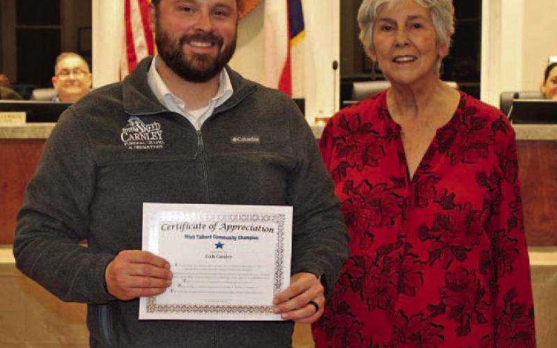 Zach Carnley of Sneed-Carnley Funeral Chapel &amp;amp; Cremations accepts the December Community Champions award from Lampasas Mayor TJ Monroe. COURTESY PHOTO