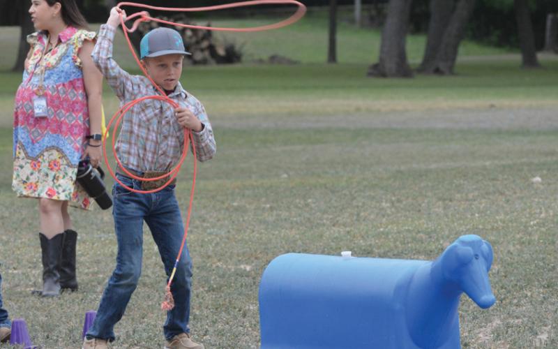 Hanna Springs second-grade student Holt Bumpus practices his lasso skills during Ag Safety Day on Friday. ERICK MITCHELL | DISPATCH RECORD